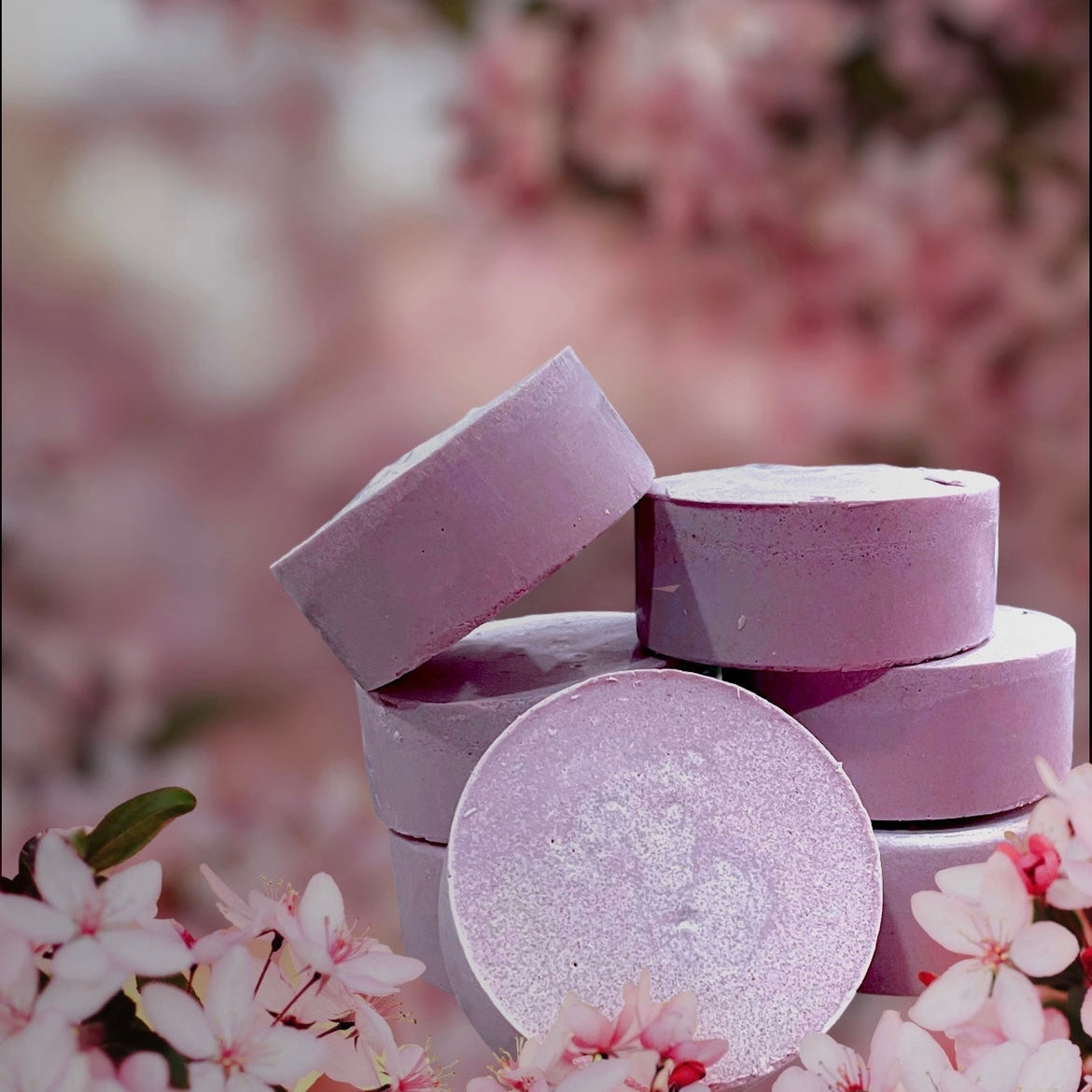 a pile of soaps sitting on top of pink flowers