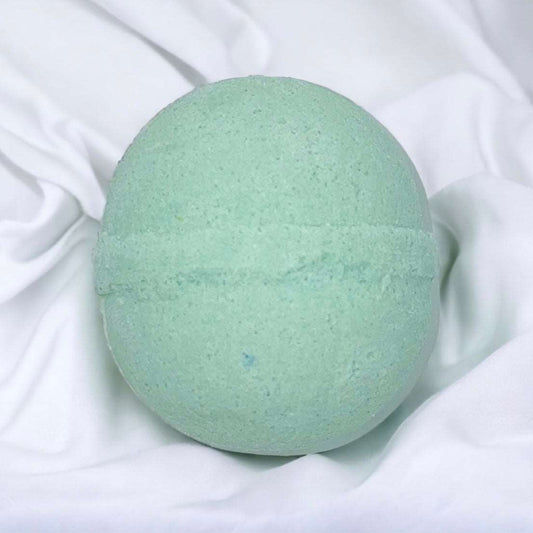 a green bath bomb sitting on a white sheet