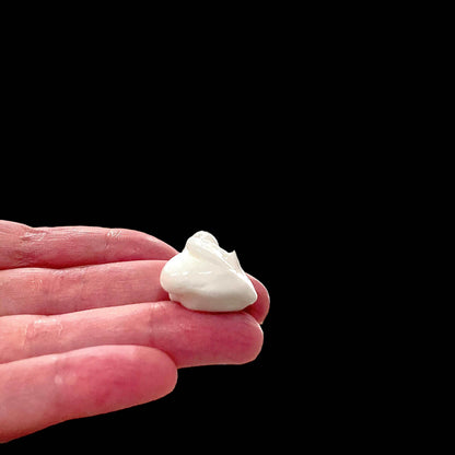 a hand holding a small piece of lotion